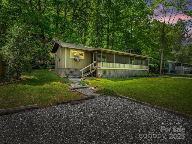 view of front facade featuring a yard and a sunroom