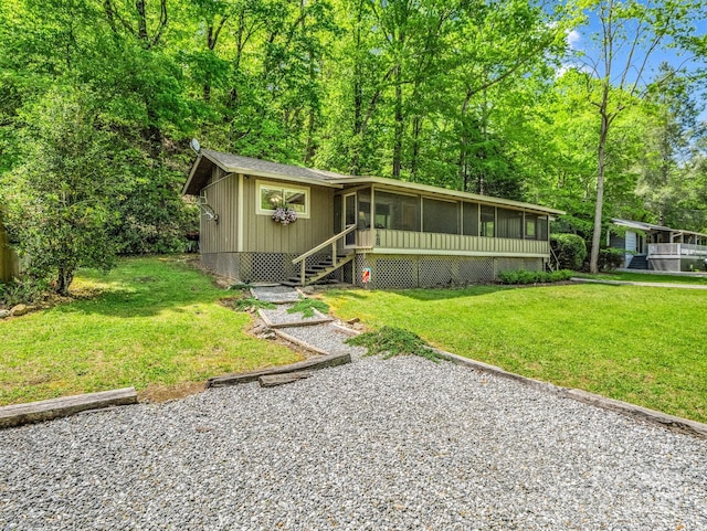 view of front of house with a sunroom and a front yard