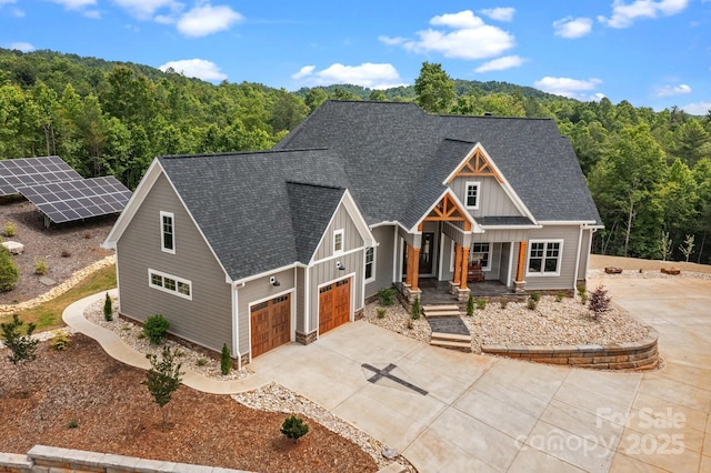 5360 Low Country Rd, Lenoir, NC 28645 - view of front of property with board and batten siding, concrete driveway, a shingled roof, and a forest view