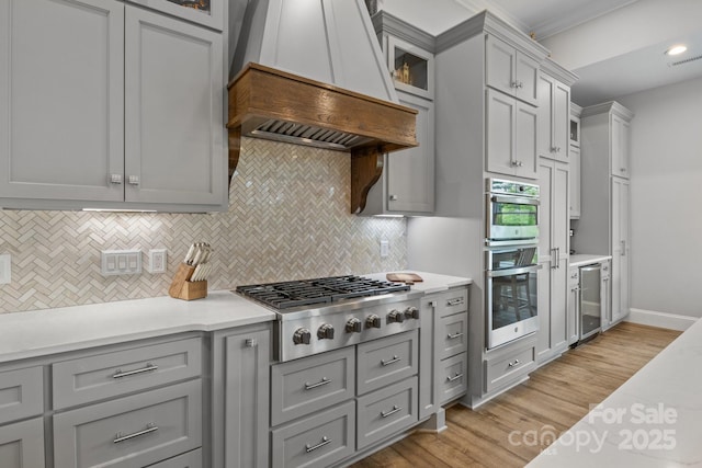 5360 Low Country Rd, Lenoir, NC 28645 - kitchen with custom exhaust hood, stainless steel appliances, gray cabinetry, beverage cooler, and decorative backsplash