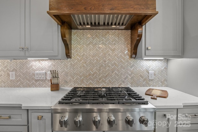 5360 Low Country Rd, Lenoir, NC 28645 - kitchen with gray cabinetry, stainless steel gas stovetop, wall chimney exhaust hood, and backsplash