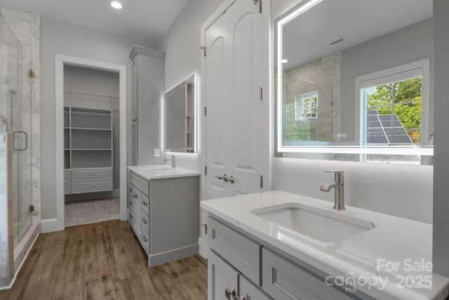 5360 Low Country Rd, Lenoir, NC 28645 - bathroom featuring a stall shower, two vanities, wood finished floors, a closet, and recessed lighting