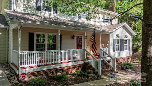 view of front facade featuring a porch, crawl space, and a chimney