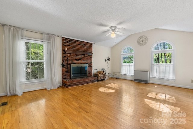 unfurnished living room featuring a brick fireplace, ceiling fan, baseboards, and light wood-type flooring