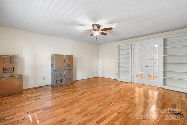 interior space with french doors, ceiling fan, baseboards, and wood finished floors