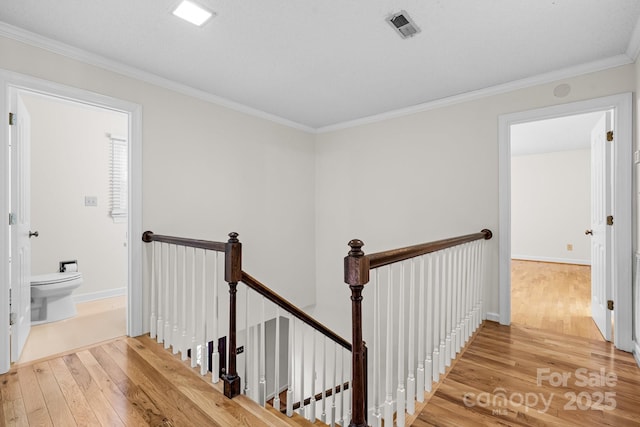 staircase with crown molding, baseboards, and hardwood / wood-style floors