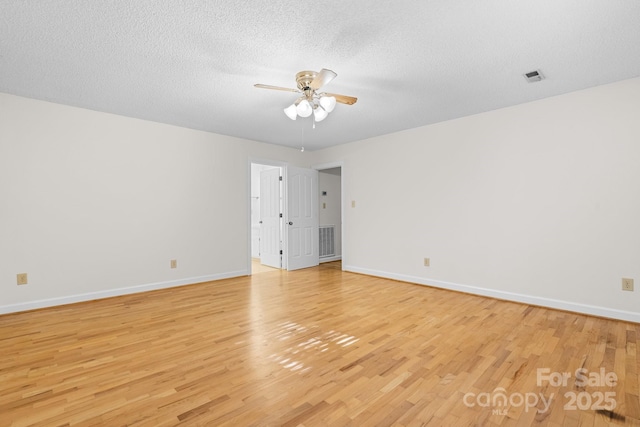 unfurnished room featuring baseboards, ceiling fan, light wood-style flooring, and visible vents