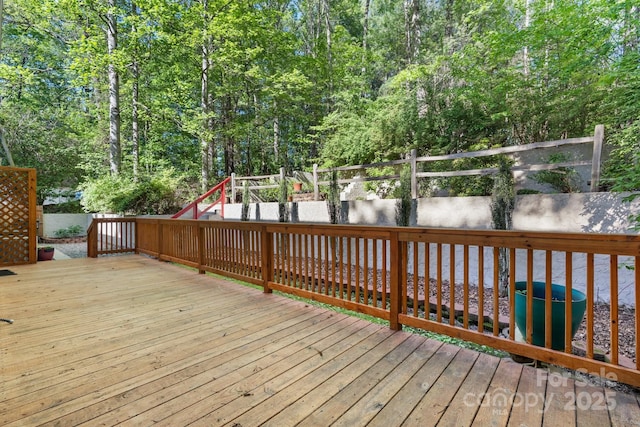 wooden terrace with a fenced backyard