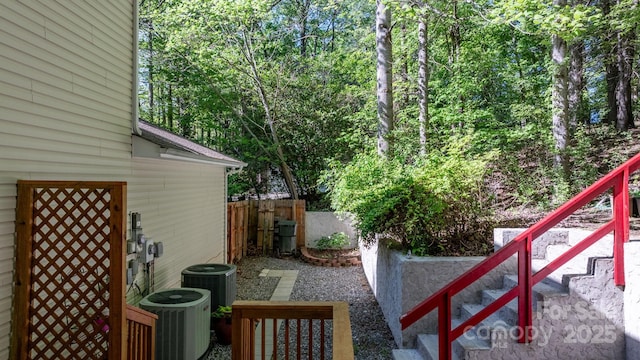 view of yard featuring central AC and fence
