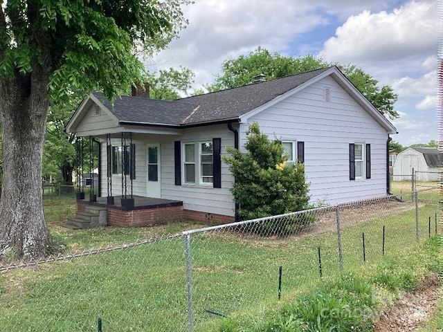 view of home's exterior with fence, a chimney, a yard, and a porch