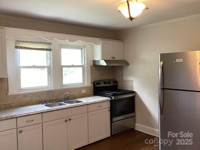 kitchen featuring appliances with stainless steel finishes, a sink, white cabinetry, backsplash, and under cabinet range hood