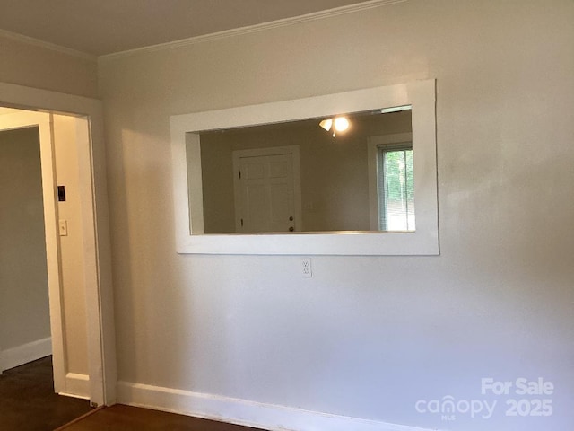 unfurnished room with baseboards, ornamental molding, and dark wood-type flooring