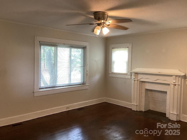unfurnished living room with baseboards, ceiling fan, dark wood-style floors, and a healthy amount of sunlight