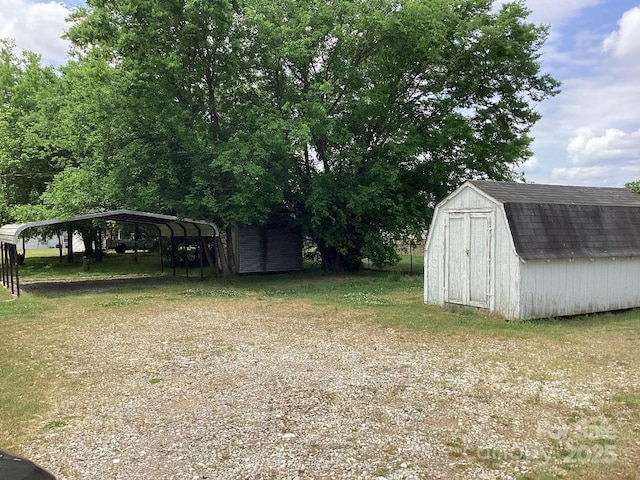 view of yard featuring a storage shed, an outdoor structure, and a carport