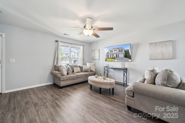 living area featuring visible vents, ceiling fan, wood finished floors, and baseboards