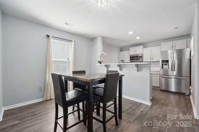dining room with an inviting chandelier, dark wood-style flooring, recessed lighting, and baseboards
