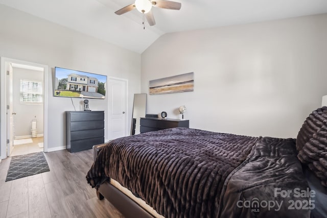 bedroom featuring connected bathroom, ceiling fan, vaulted ceiling, baseboards, and wood finished floors