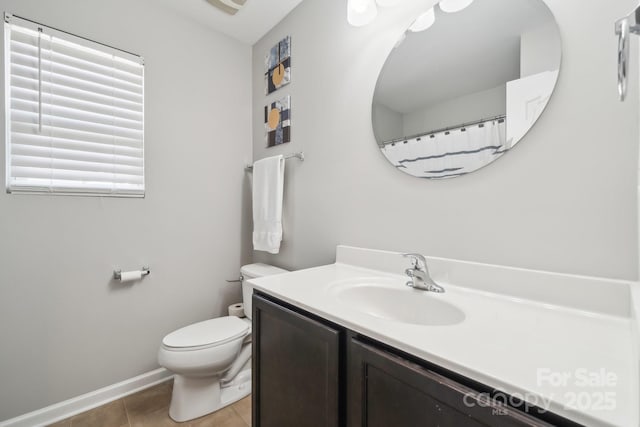 bathroom with toilet, tile patterned flooring, vanity, and baseboards