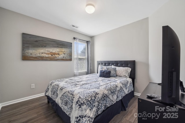 bedroom with baseboards, visible vents, and wood finished floors
