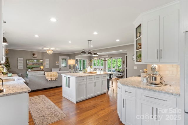 530 Bonita Dr, Landis, NC 28088 - kitchen featuring open floor plan, white cabinetry, crown molding, light wood-style floors, and decorative backsplash