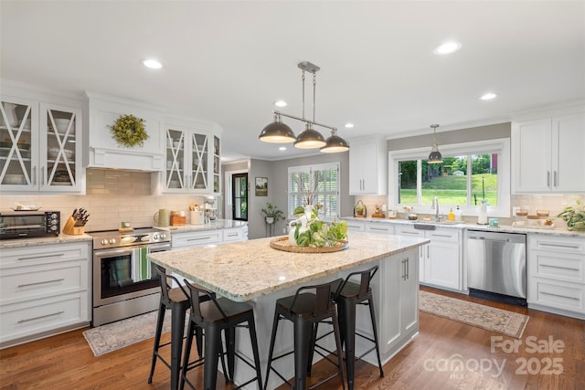 530 Bonita Dr, Landis, NC 28088 - kitchen featuring appliances with stainless steel finishes, a sink, white cabinets, a kitchen bar, and decorative backsplash