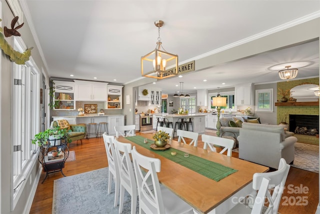 530 Bonita Dr, Landis, NC 28088 - dining space with a chandelier, plenty of natural light, wood finished floors, crown molding, and a brick fireplace