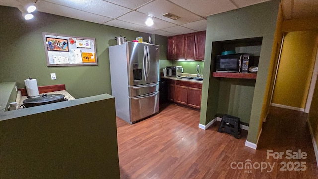 5562 Jenkins Rd, Morganton, NC 28655 - kitchen featuring light wood-type flooring, stainless steel refrigerator with ice dispenser, visible vents, black microwave, and a drop ceiling