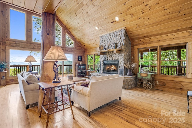living area featuring wood-type flooring, wood ceiling, a fireplace, and high vaulted ceiling