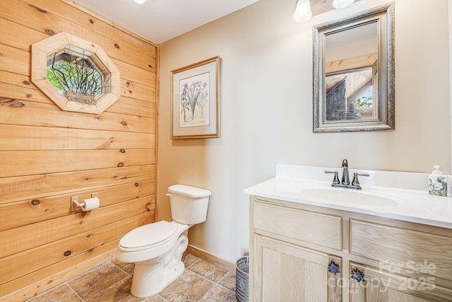 bathroom featuring vanity, baseboards, and toilet