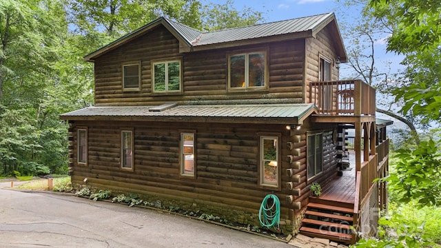 view of side of home with a deck and metal roof