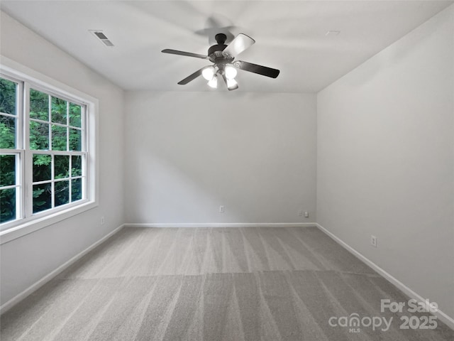 carpeted empty room featuring a ceiling fan, baseboards, and visible vents