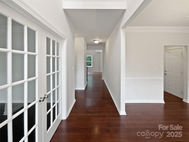 hallway with baseboards, ornamental molding, french doors, and wood finished floors