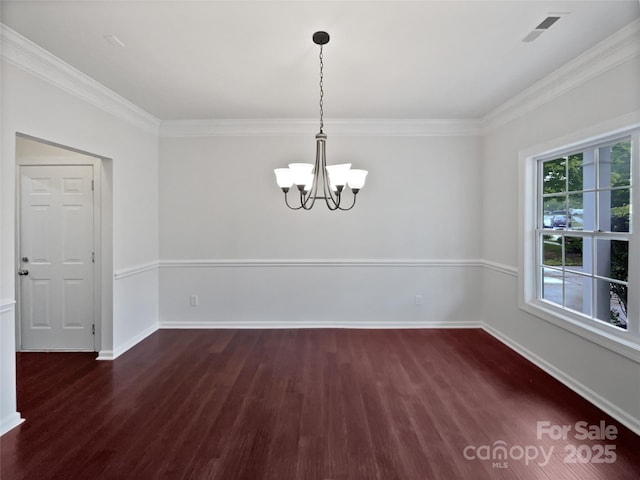 unfurnished dining area featuring baseboards, ornamental molding, wood finished floors, and a chandelier