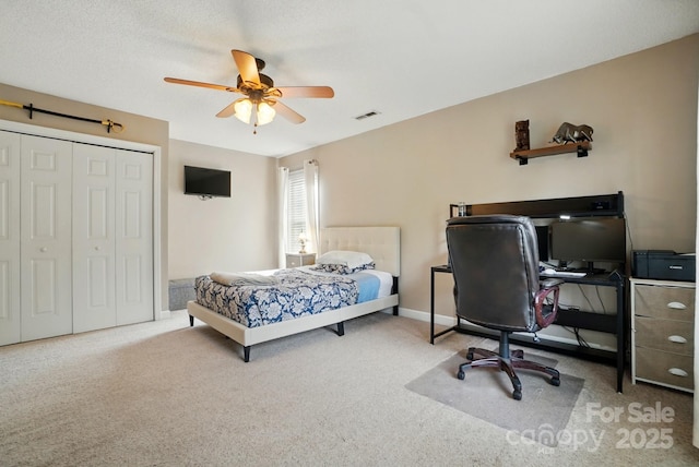 bedroom with a closet, a ceiling fan, carpet flooring, and visible vents