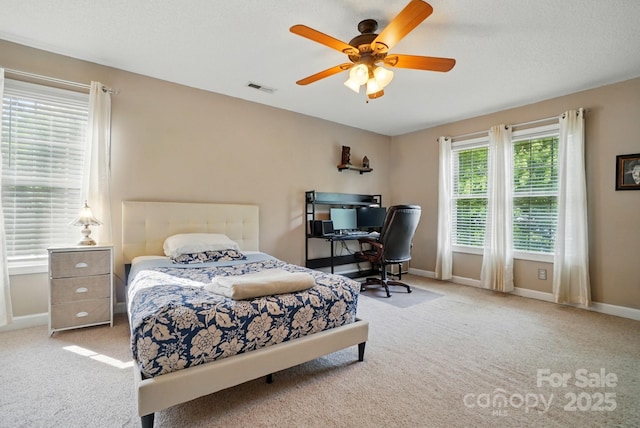 carpeted bedroom featuring visible vents, baseboards, and ceiling fan