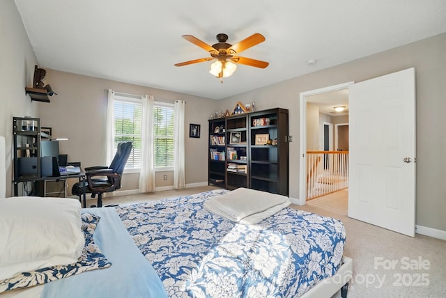 bedroom with a ceiling fan, baseboards, and light carpet