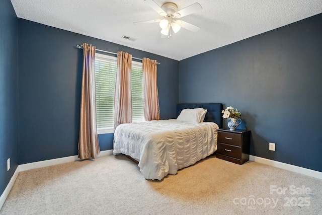 bedroom with carpet flooring, ceiling fan, a textured ceiling, baseboards, and visible vents