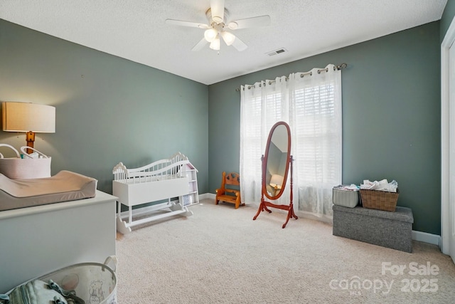 carpeted bedroom featuring visible vents, a ceiling fan, a textured ceiling, and baseboards