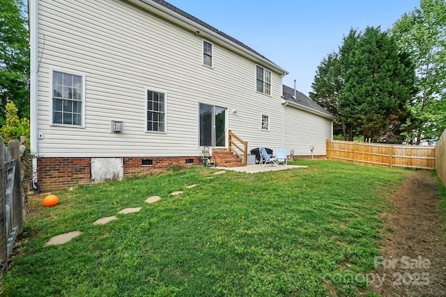back of property with a patio, a fenced backyard, crawl space, entry steps, and a yard