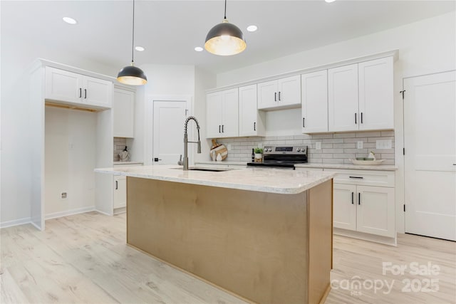 kitchen with backsplash, stainless steel range with electric cooktop, a sink, light wood finished floors, and white cabinetry
