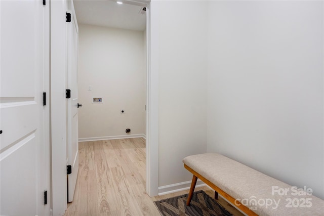 hallway featuring baseboards, light wood-style flooring, and visible vents