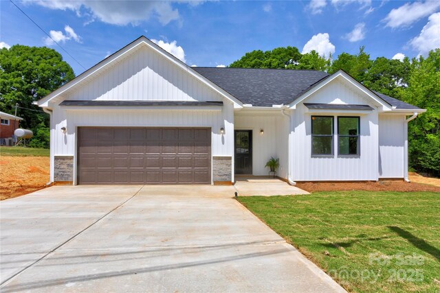 3300 Travis Ln NW, Concord, NC 28027 - modern inspired farmhouse with an attached garage, concrete driveway, a front lawn, and stone siding
