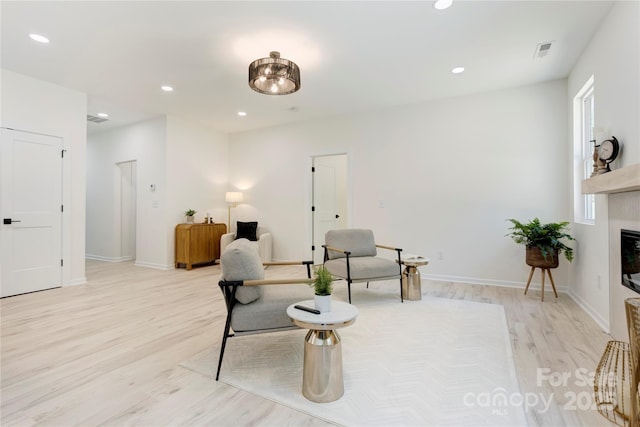 3300 Travis Ln NW, Concord, NC 28027 - sitting room with visible vents, recessed lighting, light wood-style flooring, and a glass covered fireplace
