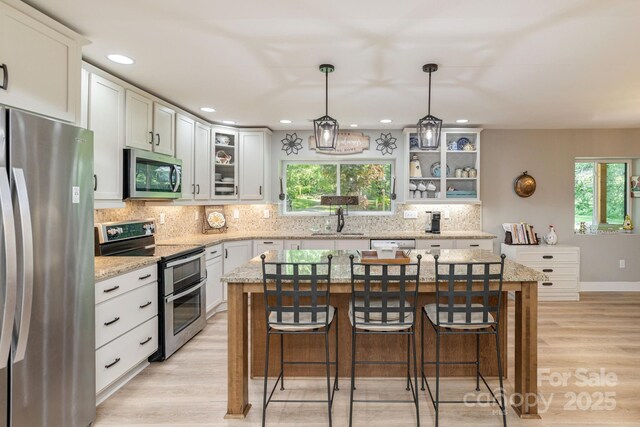4329 Island Ford Rd, Brevard, NC 28712 - kitchen with stainless steel appliances, a breakfast bar, light wood-type flooring, backsplash, and recessed lighting