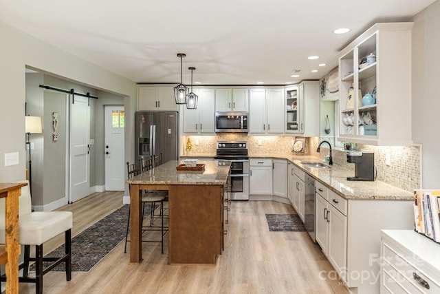4329 Island Ford Rd, Brevard, NC 28712 - kitchen with stainless steel appliances, light wood-style flooring, a sink, a breakfast bar area, and recessed lighting