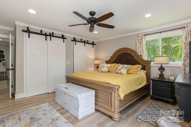 4329 Island Ford Rd, Brevard, NC 28712 - bedroom featuring a barn door, crown molding, light wood-style floors, recessed lighting, and ceiling fan