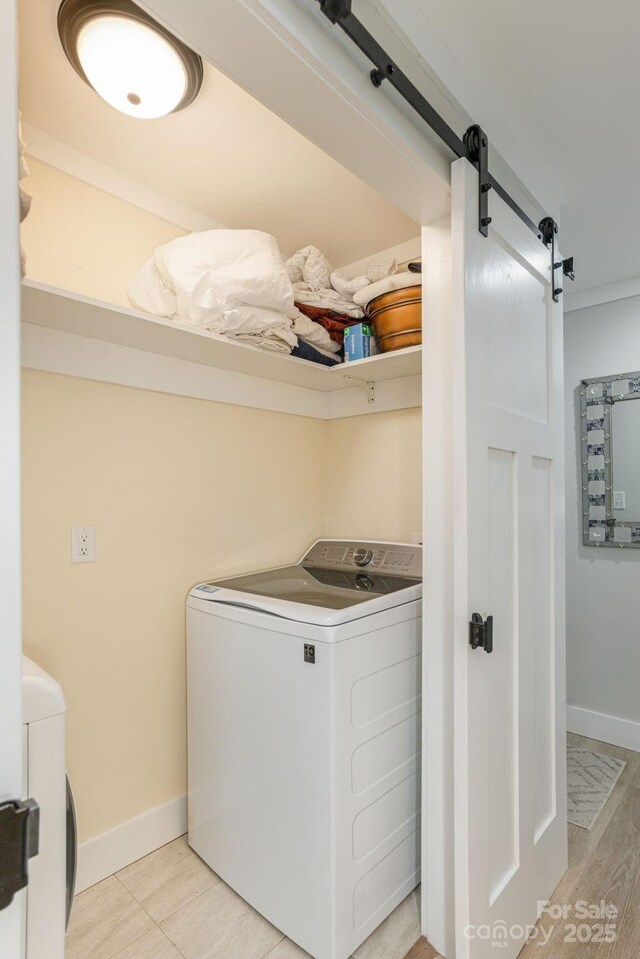 4329 Island Ford Rd, Brevard, NC 28712 - washroom with washing machine and clothes dryer, a barn door, and baseboards