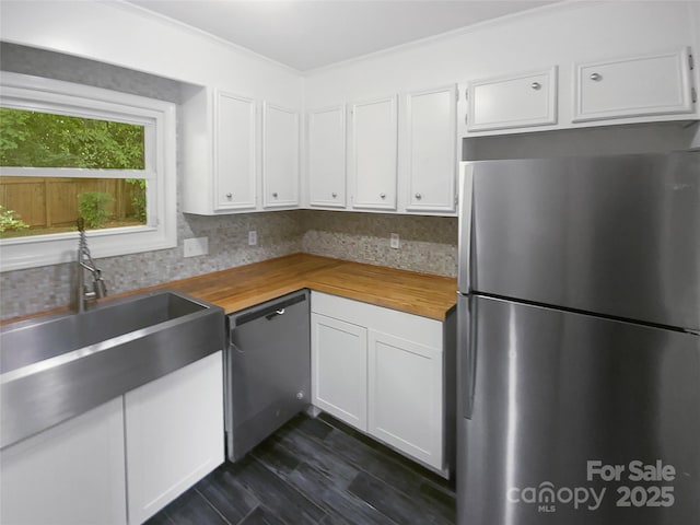 kitchen featuring wood counters, appliances with stainless steel finishes, and backsplash