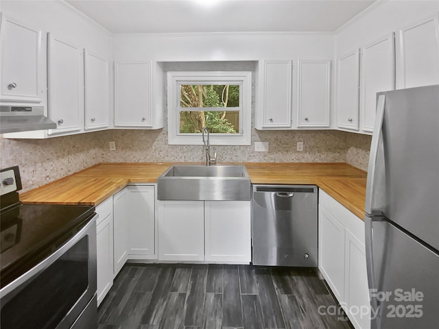 kitchen featuring appliances with stainless steel finishes, a sink, wood counters, white cabinetry, and under cabinet range hood