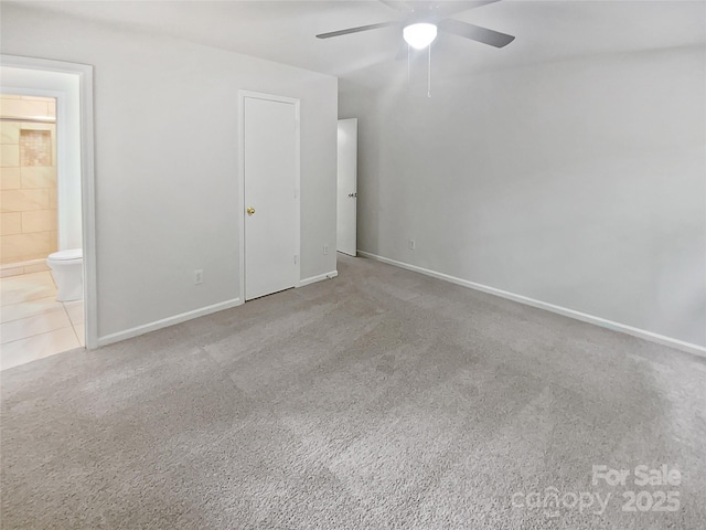 unfurnished bedroom with connected bathroom, baseboards, ceiling fan, and carpet